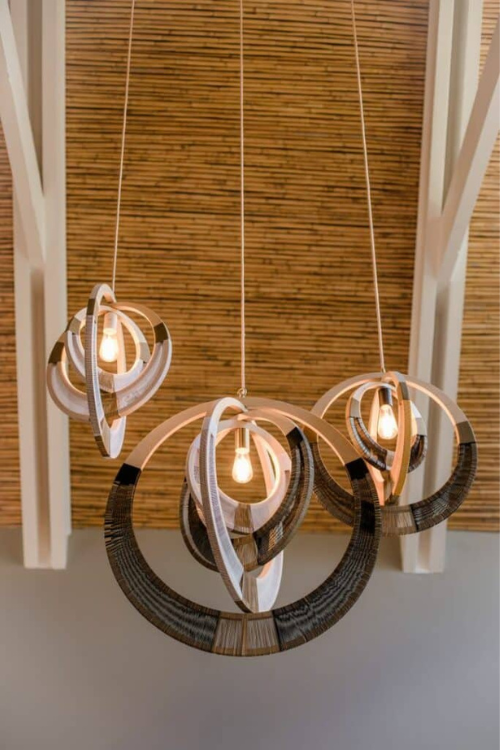 South African woven necklace pendant light by September Collective, showcasing intricate woven design and warm lighting.