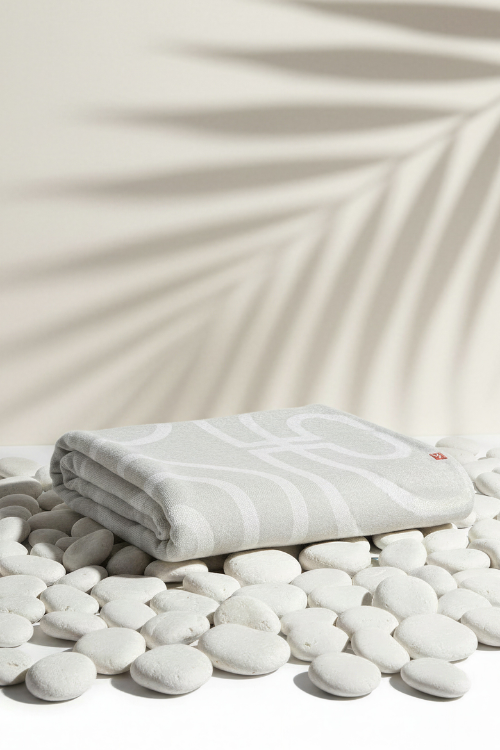 Villa Aburi Krado Knit Blanket folded on white rocks
