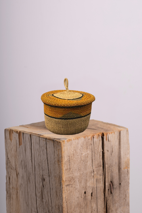 Baba-Tree-Banasco-Basket-Desert-Grove-september-collective with a lid on a wooden block against a light gray background
