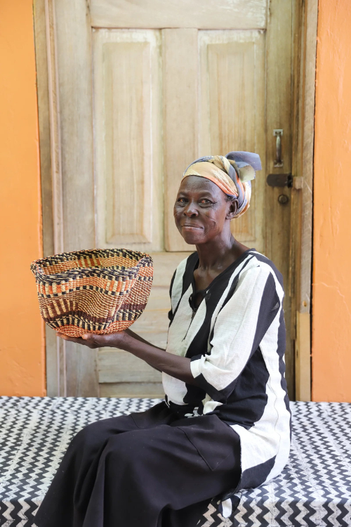 Baba Tree artisan holding Petite Pakurigo Wave Basket - Gurunsi