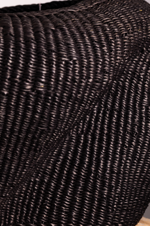 Close-up of a baba tree woven black basket with a textured surface.