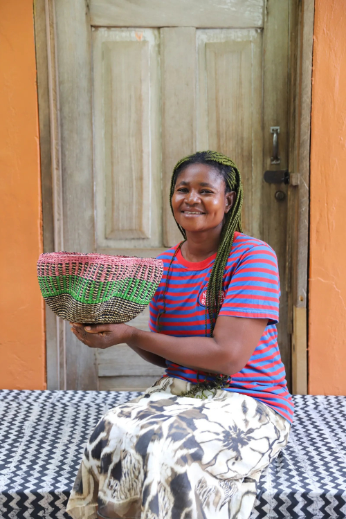 Small Baba Tree Pakurigo Wave Basket in vibrant mirage colors, held by an artisan, showcasing its woven storage design.