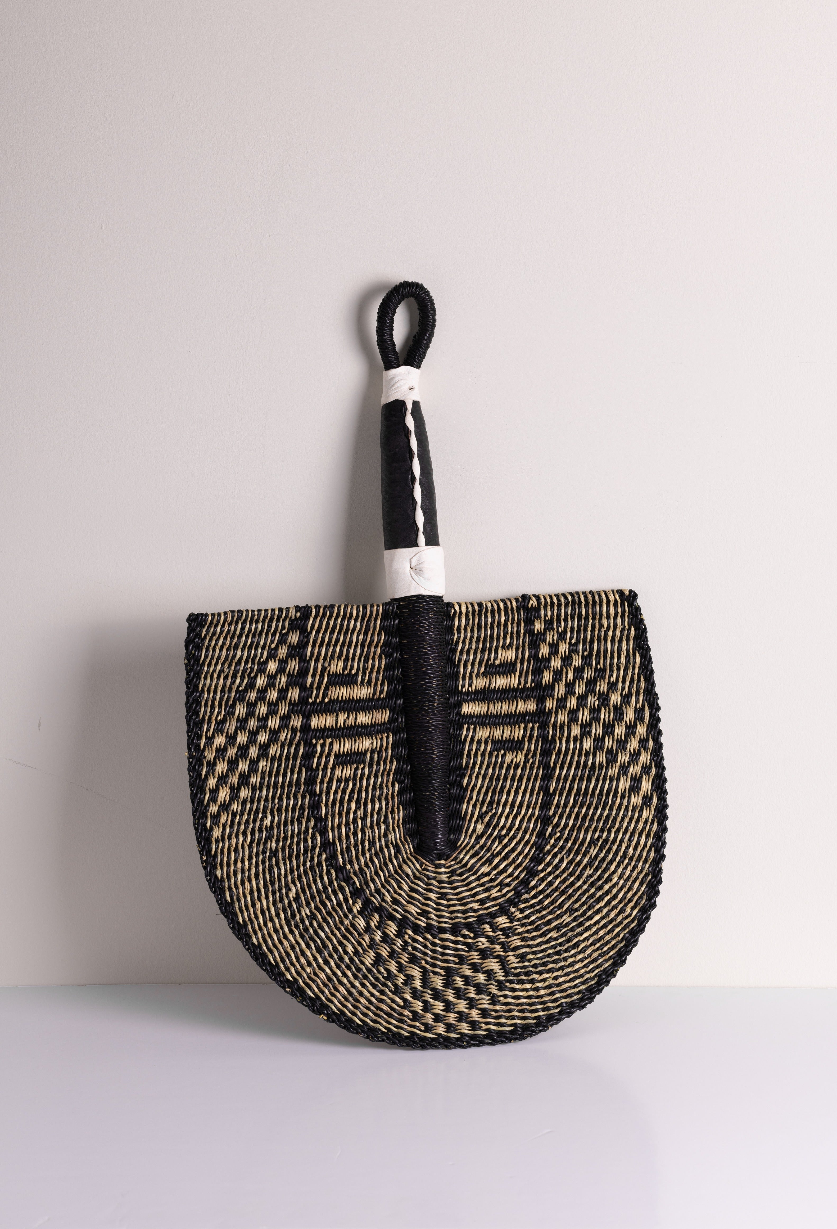 Handcrafted Bolga decorative wall fan with black geometric design, natural handwoven from Ghana by Baba Tree.