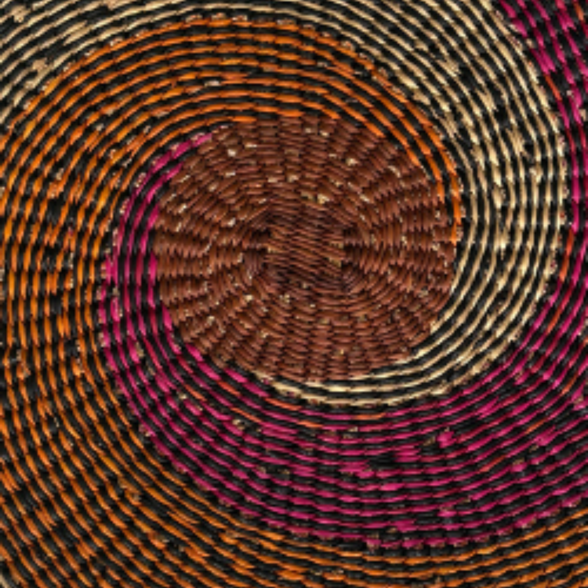 Baba Tree Placemats - African Tide. Close-up of a woven circular pattern with concentric circles in brown, pink, and orange.