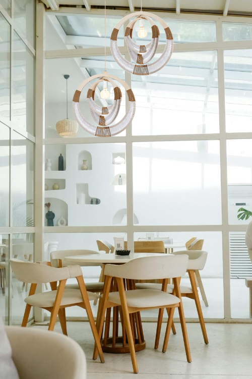 South African woven necklace pendant light by September Collective hanging against a neutral background.