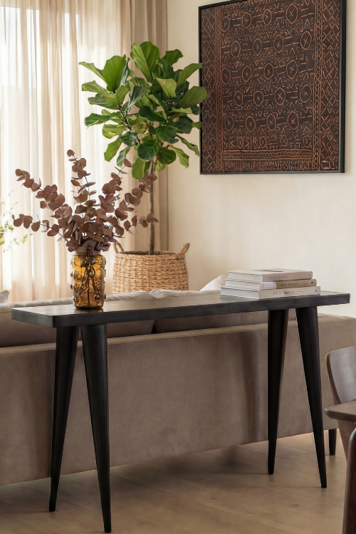 Black Tekura walking console with sleek modern design, shown in a close-up view in a stylish room setting.