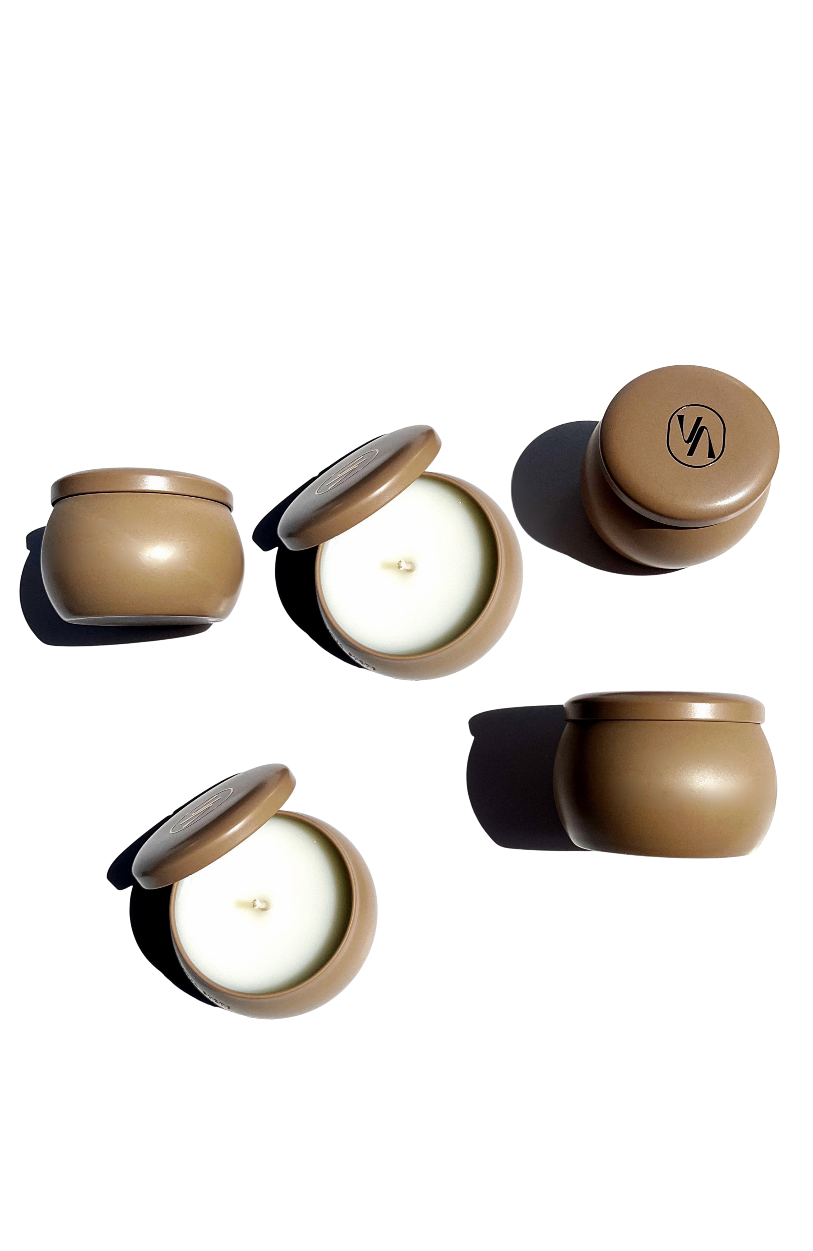 Set of beige Villa Aburi travel sized candles with lids on a white background
