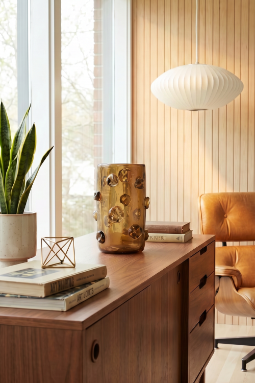 Kitengela Glass NweLe Vase Umber glass sculpture with smooth, rounded design and warm amber color on a neutral background