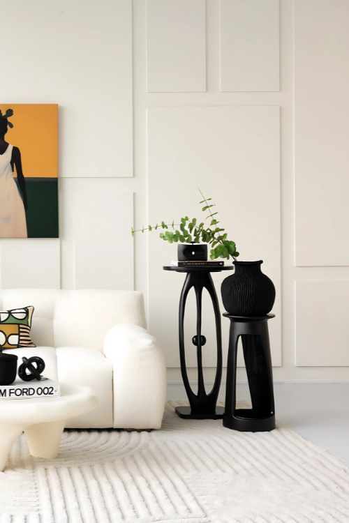 Modern living room with white sofa, black and white patterned pillow, and baba tree black jemima 10 cows basket.