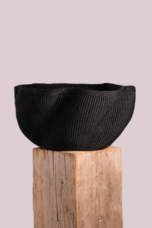 Baba Tree Black pakurigo wave basket on a wooden stand against a light gray background at september collective