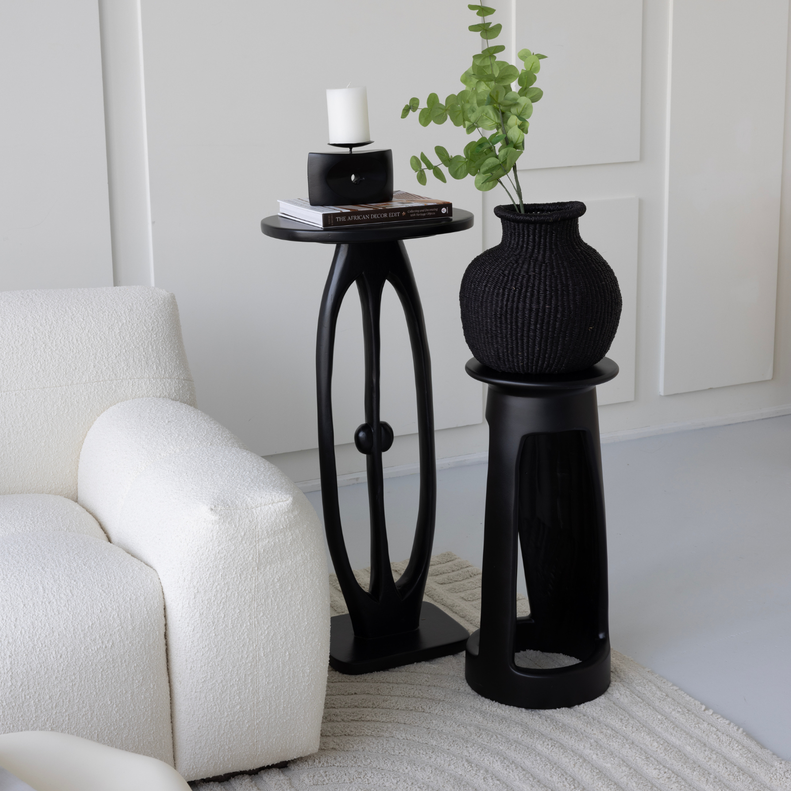 Tekura Djembe Black side table next Crab table beside a white armchair in a living room.