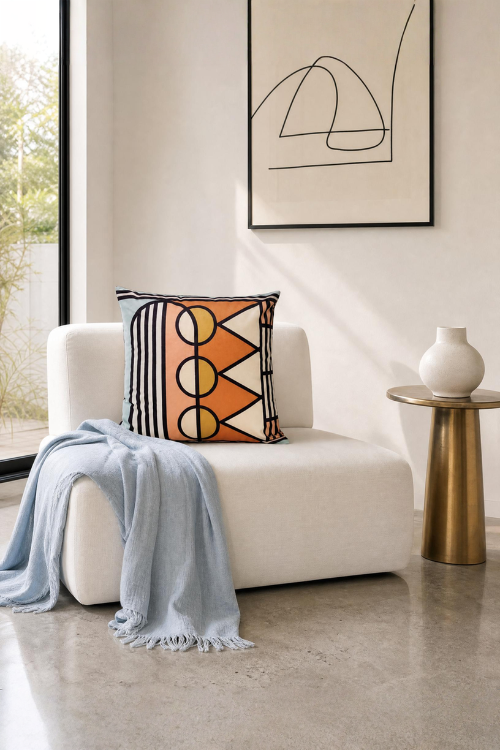 Lulasclan matsatsi velvet pillow on a white sofa with a gold side table and abstract art in the background