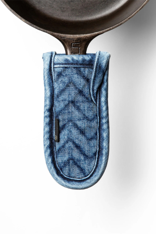 Mi cocina Denim Herringbone Quilted Pan Handle Holder on a cast iron skillet.