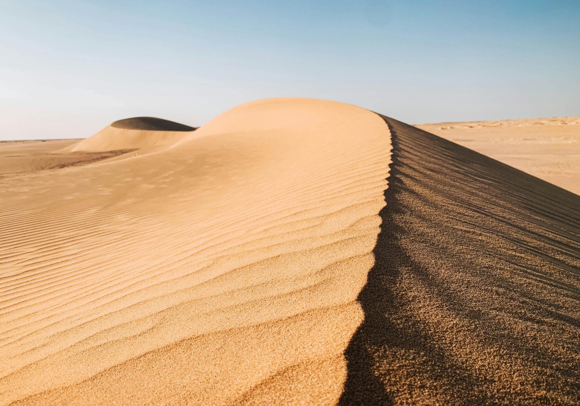 Desert landscape with sand dunes under a clear blue sky