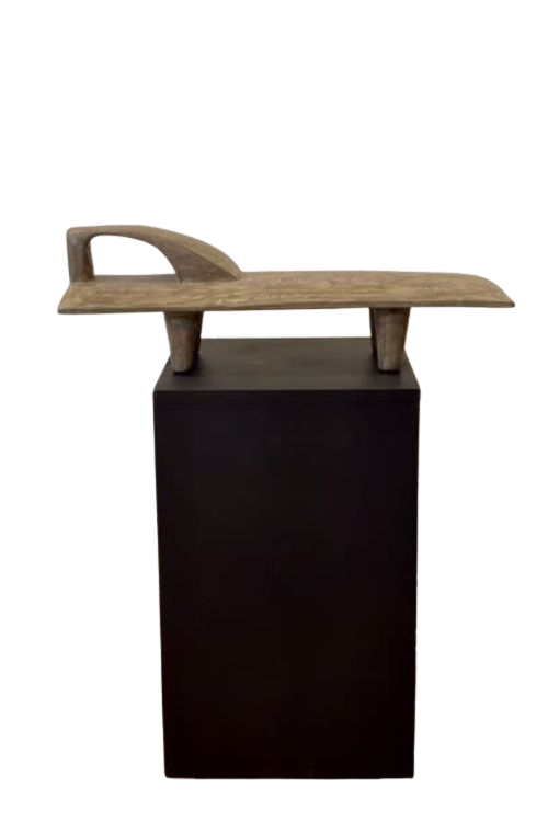 Senufo Sculpture Stand by Tekura seated on a stand.