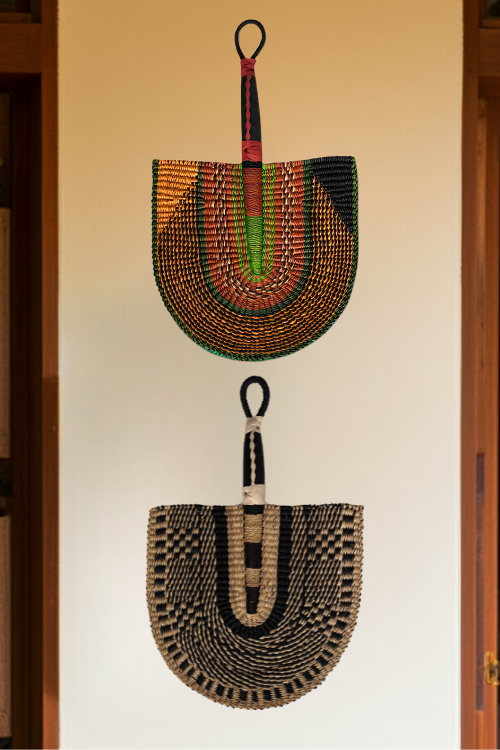 Handcrafted Bolga Decorative Fan – Kente Geometric Design. Two Baba Tree Bolga Decorative Fans styled on a wall. Handwoven Elegance from Ghana is a cost-conscious way to bring authentic African craftsmanship into your home.
