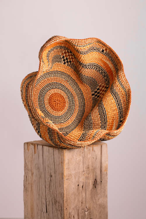 Colorful Pakurigo Wave Basket by Baba Tree for storage, featuring a multi-colored orange and brown woven design.