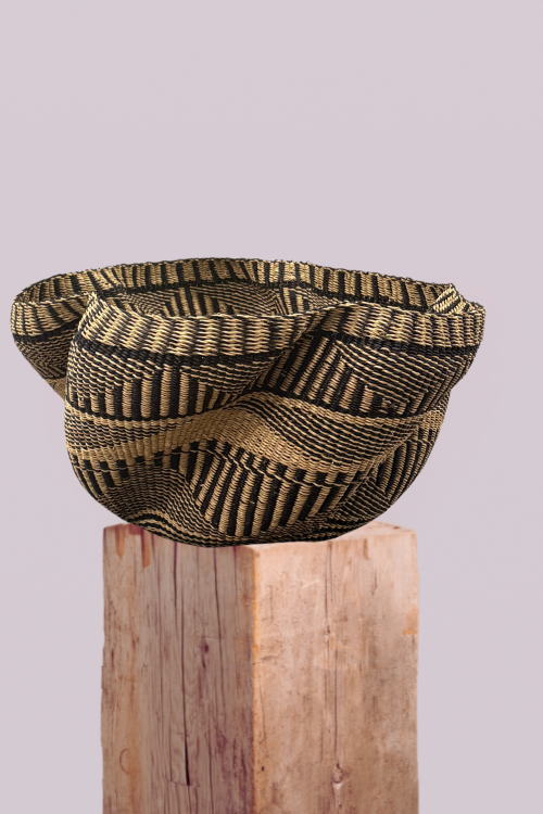 Pakurigo Wave Basket - Black and Natural Essence on a wooden block against a light gray background