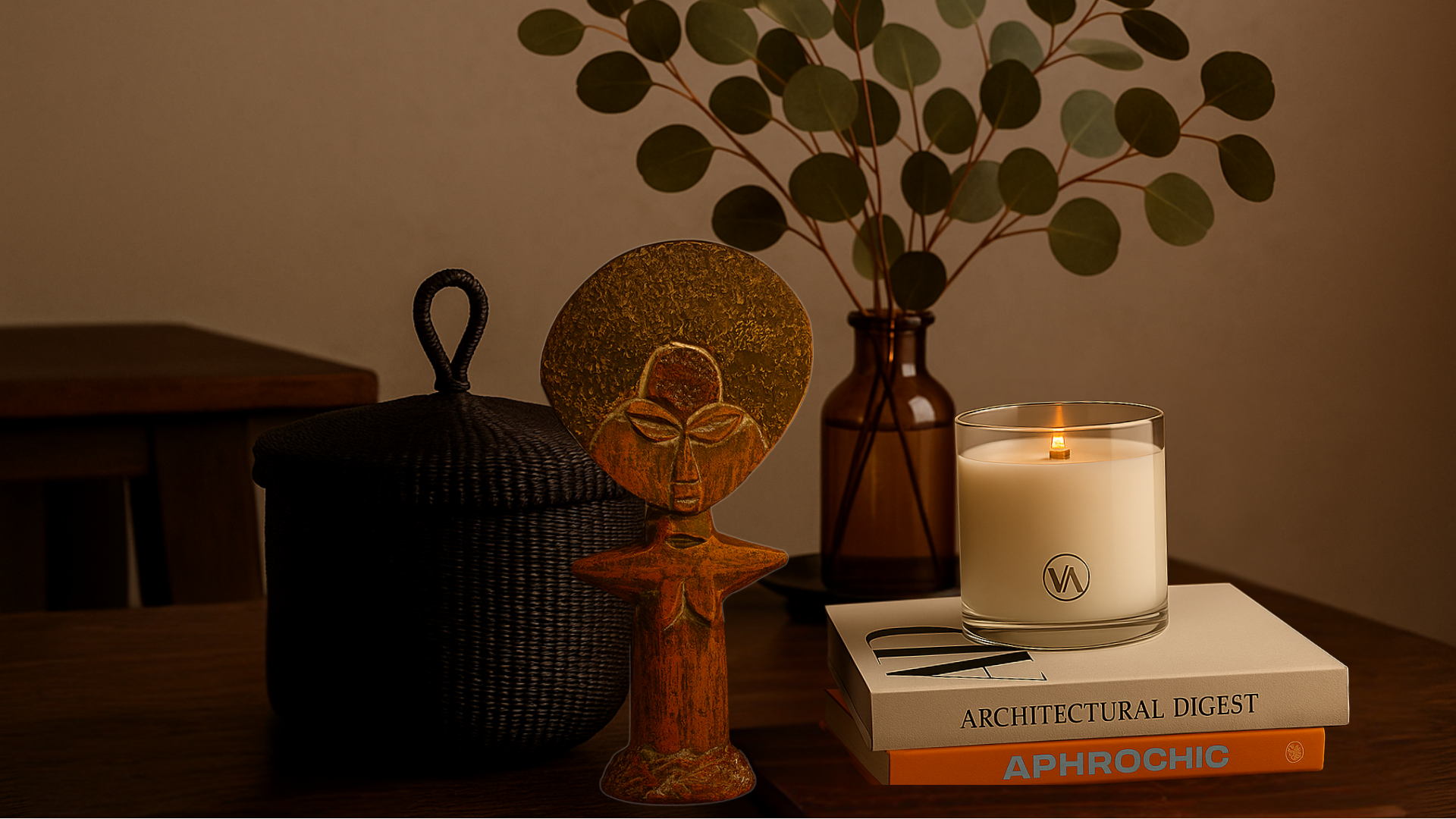 Candle burning on a stack of books with decorative items on a table.