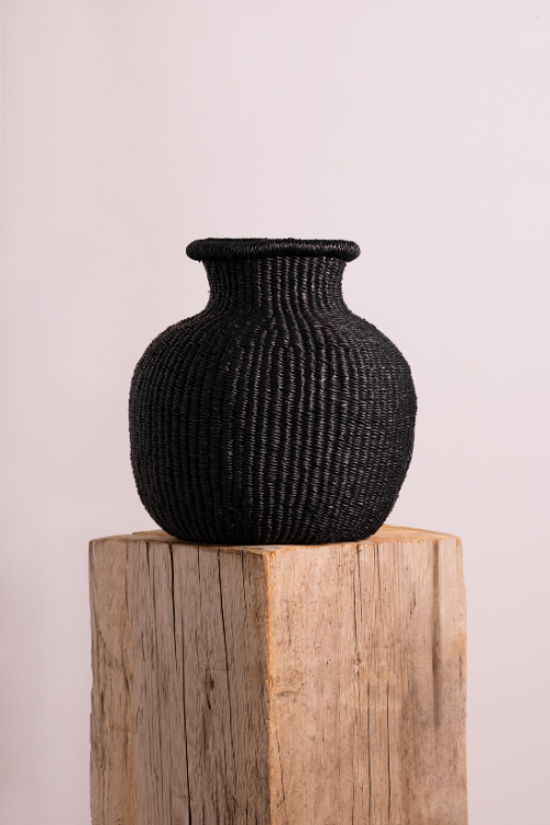 Baba tree jemima 10 cows tiny basket in Black on a wooden block against a light pink background