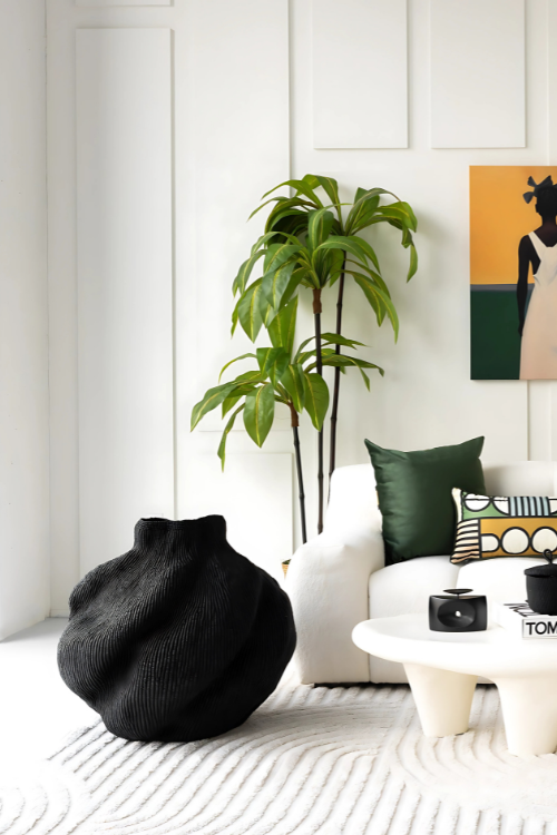Modern living room with a black baba tree yoomelingah basket with white sofa, and decorative pillows.
