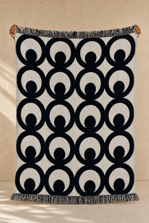 Villa Aburi Mate Masie woven throw blanket in black and cream jacquard design made from 100% organic cotton.