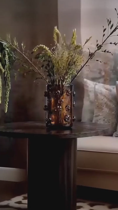 Video showing Nywele vase on table, a black woman, a door opening an the Obaa wall totem shown and a black and white art piece of an african woman in traditional wear.